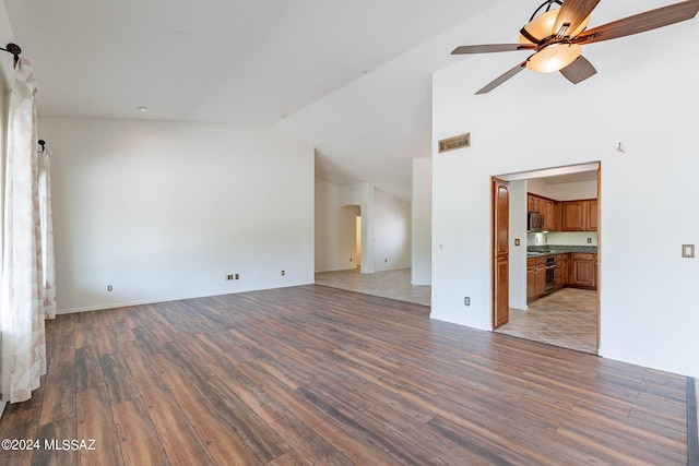 unfurnished living room featuring ceiling fan, wood-type flooring, and high vaulted ceiling