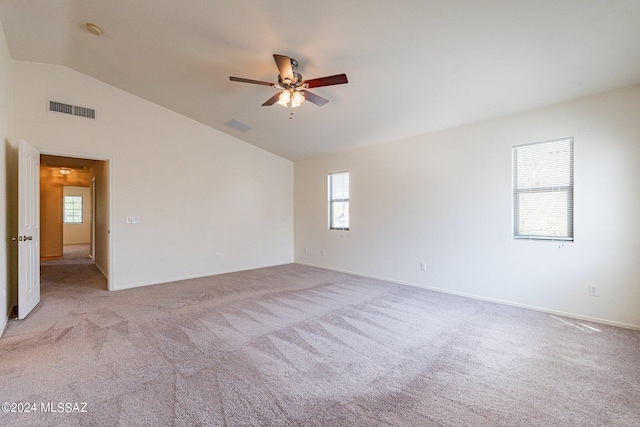 empty room with ceiling fan, lofted ceiling, and light carpet