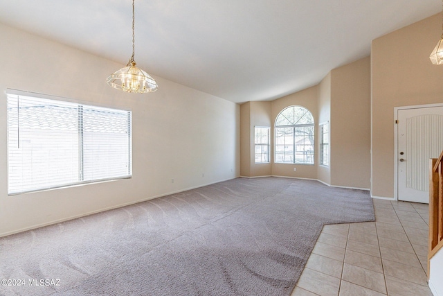 carpeted empty room featuring high vaulted ceiling