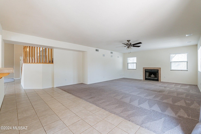 unfurnished living room with light colored carpet and ceiling fan