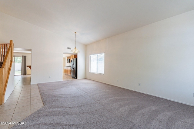 empty room with light carpet and high vaulted ceiling