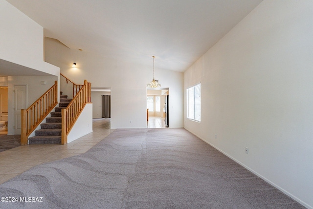 unfurnished living room featuring light tile patterned flooring and high vaulted ceiling