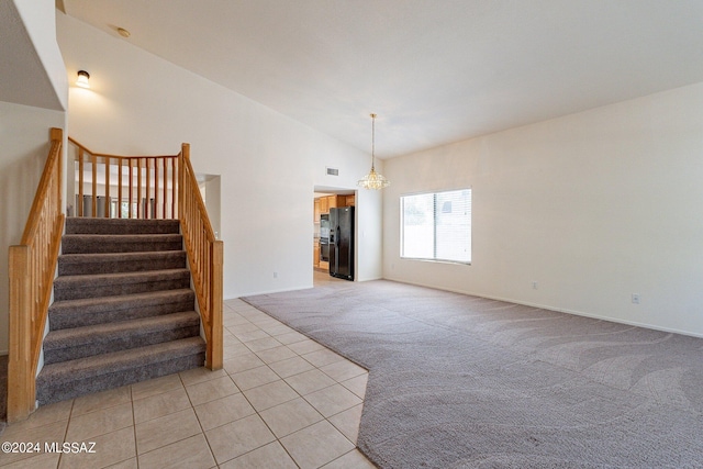 staircase featuring a notable chandelier, high vaulted ceiling, and carpet