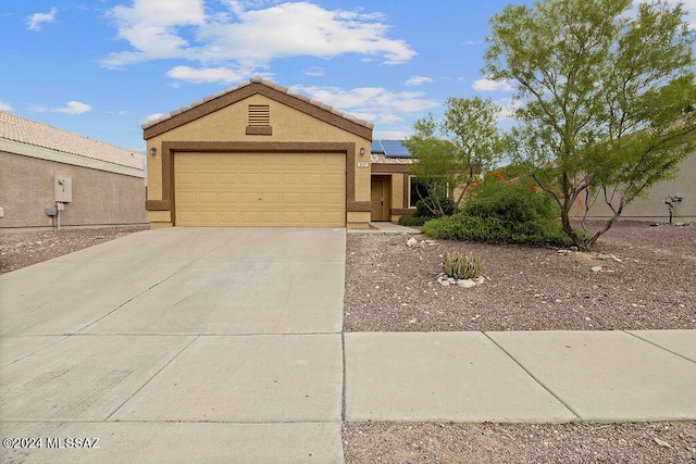 view of front of property with a garage and solar panels