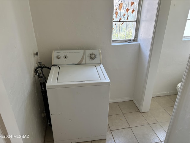 clothes washing area featuring light tile patterned floors and washer / dryer