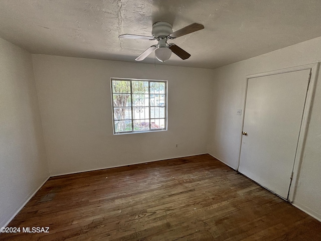 interior space featuring dark wood-type flooring, ceiling fan, and a textured ceiling