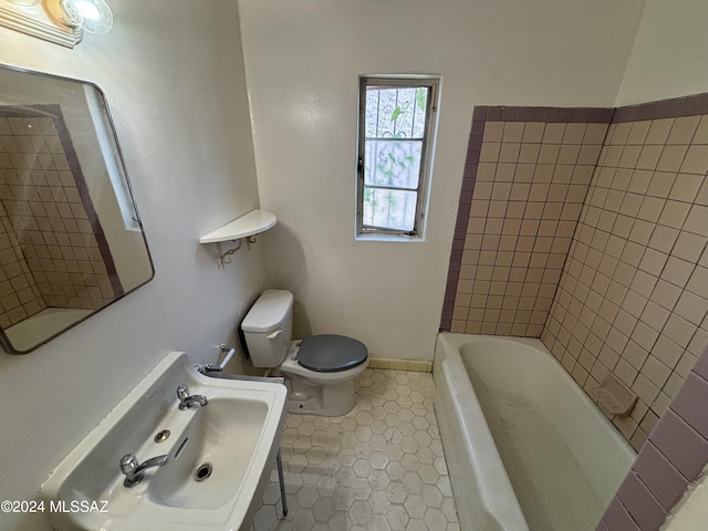 bathroom with tile patterned flooring, a bathtub, and toilet