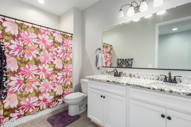 bathroom featuring vanity, hardwood / wood-style flooring, and toilet