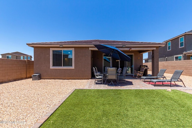 rear view of house featuring a patio and a lawn