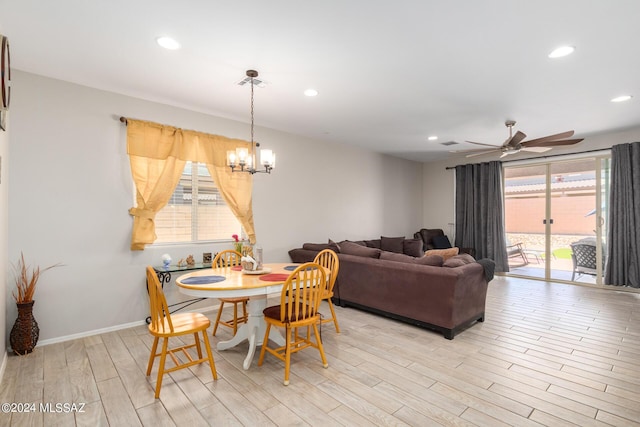 dining room with ceiling fan with notable chandelier and light hardwood / wood-style flooring