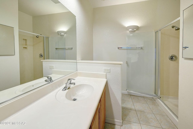 bathroom with tile patterned flooring, vanity, and an enclosed shower