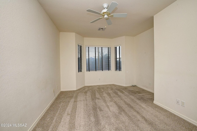 spare room with ceiling fan and light carpet