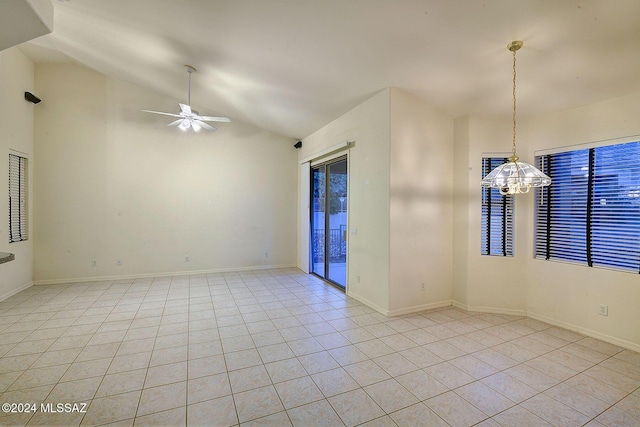 tiled spare room with ceiling fan with notable chandelier and lofted ceiling