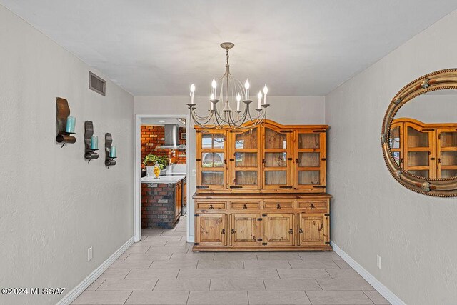 tiled dining room with an inviting chandelier