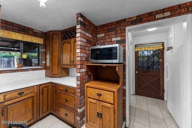 kitchen featuring light tile patterned flooring, white fridge, and a wealth of natural light