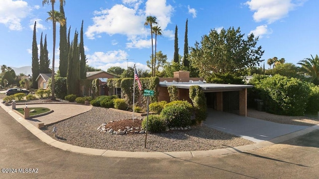 view of front of house with concrete driveway and an attached carport