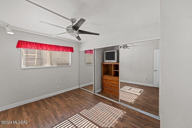 unfurnished bedroom featuring a closet, wood finished floors, a ceiling fan, and baseboards