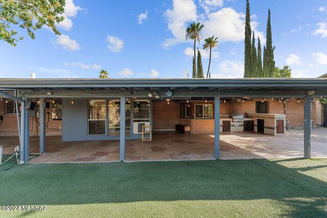 rear view of property featuring area for grilling, a yard, and a patio