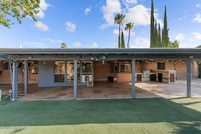 rear view of house featuring a patio area, exterior kitchen, and brick siding