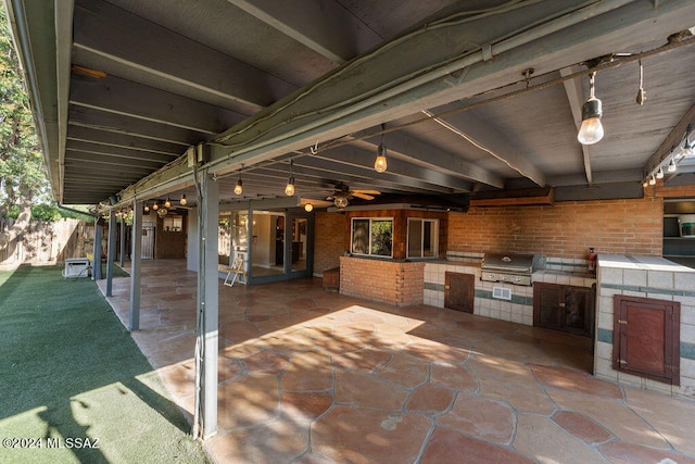 view of patio with an outdoor kitchen, ceiling fan, and grilling area