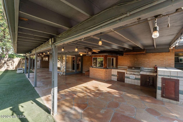 view of patio featuring a ceiling fan, area for grilling, and an outdoor kitchen