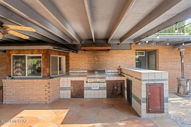 view of patio with an outdoor kitchen, ceiling fan, and grilling area