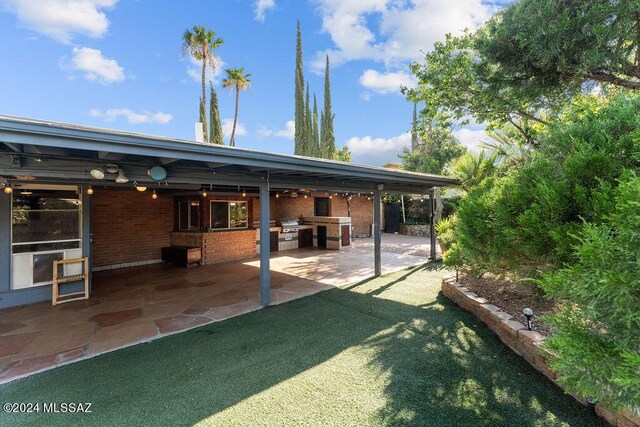 back of property with a patio, a yard, and ceiling fan