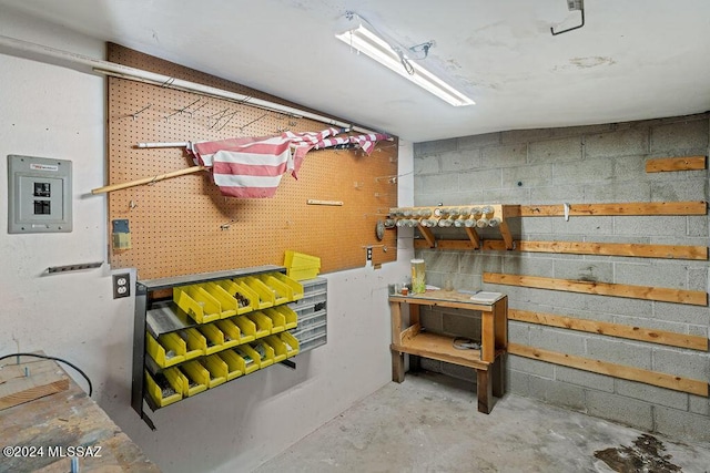 finished basement featuring concrete block wall and a workshop area