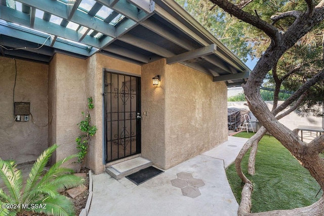 doorway to property featuring stucco siding