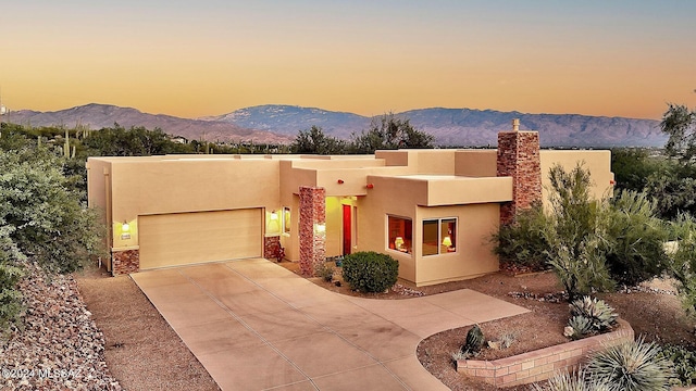 adobe home featuring a mountain view and a garage