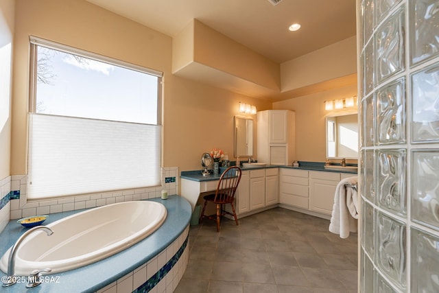 bathroom featuring vanity and tiled tub