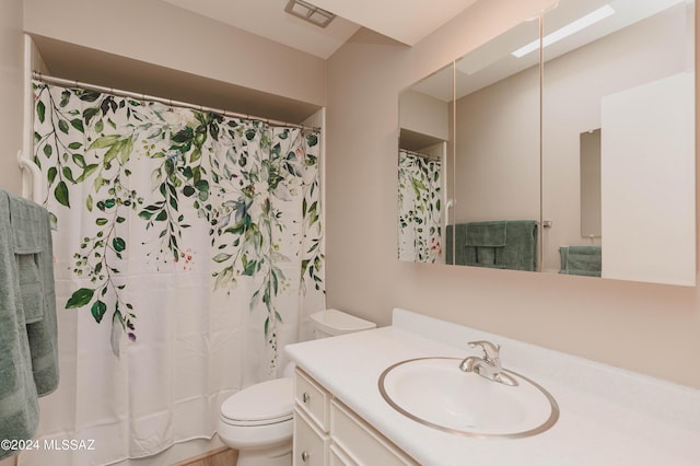 bathroom featuring toilet, a shower with shower curtain, and vanity