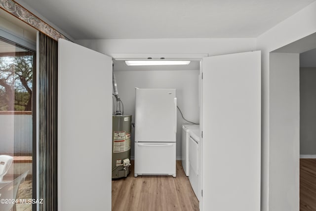 kitchen with light wood-type flooring, water heater, white refrigerator, and separate washer and dryer