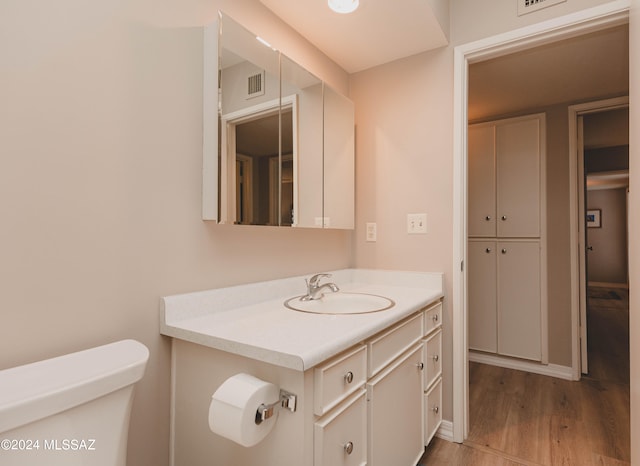 bathroom featuring vanity, hardwood / wood-style floors, and toilet