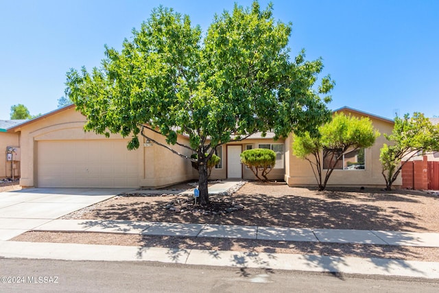 obstructed view of property with concrete driveway, an attached garage, and stucco siding