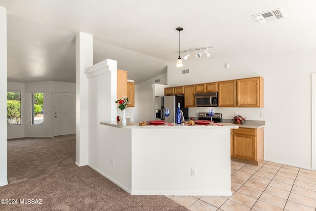 kitchen featuring pendant lighting, lofted ceiling, kitchen peninsula, light carpet, and stainless steel appliances