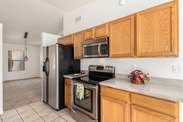 kitchen featuring pendant lighting, stainless steel appliances, lofted ceiling, and light colored carpet