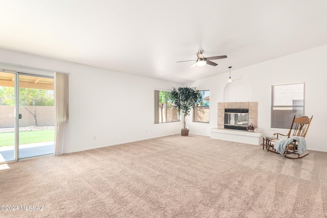 unfurnished living room featuring carpet, ceiling fan, vaulted ceiling, and a fireplace