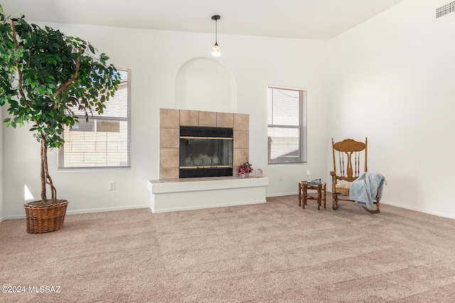 living area featuring a healthy amount of sunlight, a fireplace, and light colored carpet