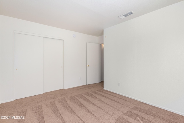 unfurnished bedroom with carpet and a closet