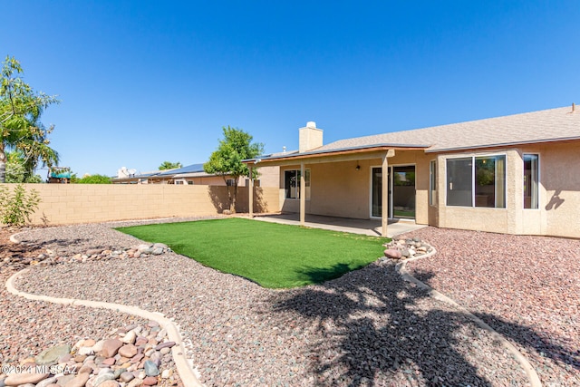 rear view of property featuring a lawn and a patio