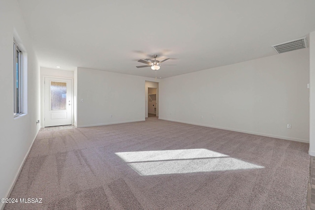 spare room with ceiling fan and light colored carpet