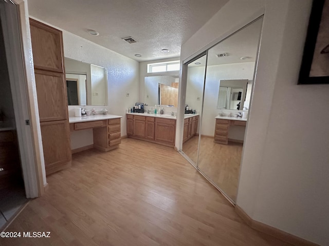 bathroom with hardwood / wood-style flooring, vanity, and a textured ceiling