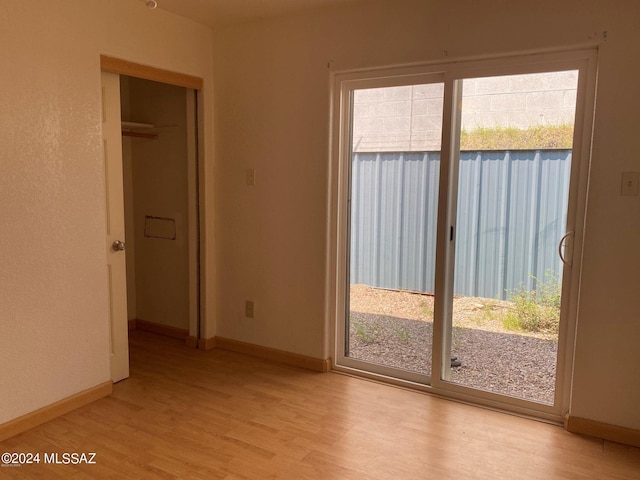 unfurnished bedroom with access to outside and light hardwood / wood-style floors