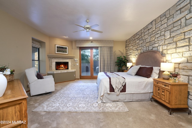 carpeted bedroom featuring french doors, a fireplace, access to outside, and ceiling fan