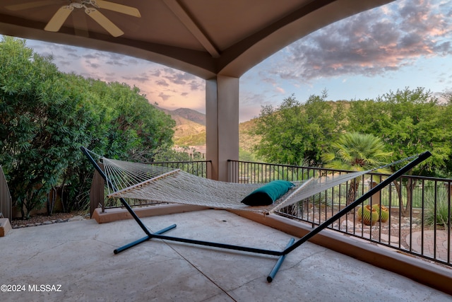 balcony at dusk with a mountain view and ceiling fan