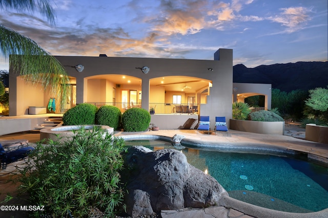 back house at dusk with a patio area