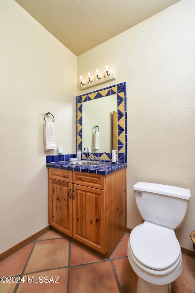 bathroom featuring vanity, toilet, and tile patterned flooring