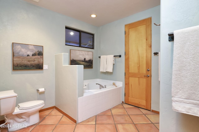 bathroom featuring tile patterned floors, tiled tub, and toilet