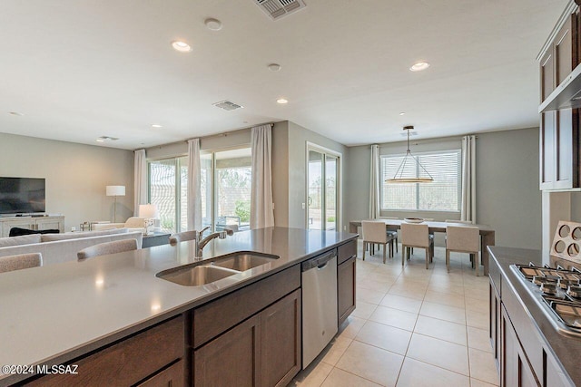 kitchen with appliances with stainless steel finishes, pendant lighting, visible vents, and a sink